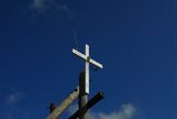 A cross on a telephone pole with a CB Antenna on top.